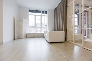 View of white armchairs and laptop in spacious and modern waiting room at office