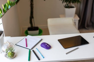 Kalem ve kalemle ahşap çalışma masasına koyulan tablet.