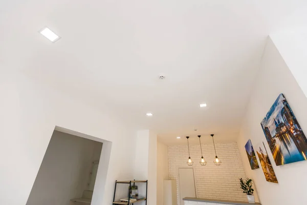White ceiling with spot lights in room.
