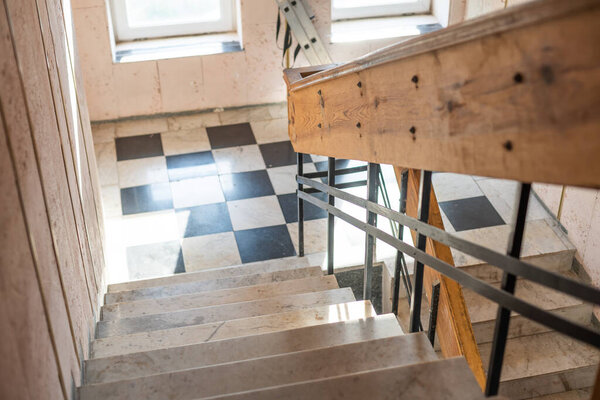 вид через дверной проем в пустой старой вилле с деревянным паркетным полом на решетчатое окно от тёмного до светлого
.