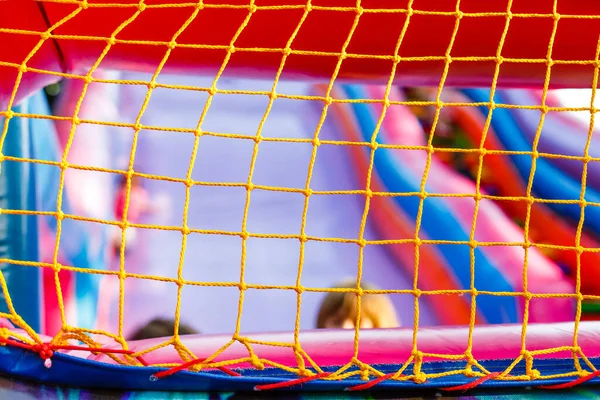mesh on an inflatable trampoline. Active games for children.