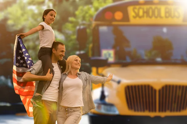 Счастливая Молодая Семья Национальными Флагами Сша Возле Школьного Автобуса — стоковое фото