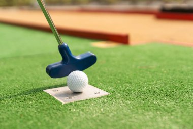 Yapay çimlerin üzerinde mini golf topu. Yaz sezonu oyunu.
