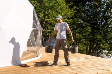 the master builds the dome. Outside spherical glamping dome. Hemispherical structure lattice shell geodesic polyhedron. Camping house hotel party tent