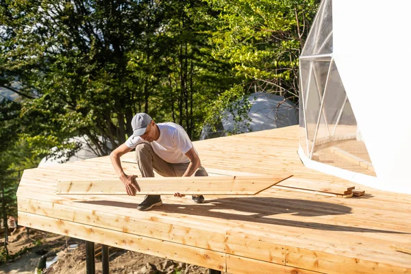 the master builds the dome. Outside spherical glamping dome. Hemispherical structure lattice shell geodesic polyhedron. Camping house hotel party tent