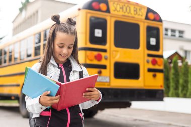 Child going back to school. Start of new school year after summer vacation. Little girl with backpack and books on first school day. Beginning of class.