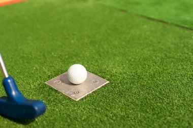 Minyatür golf delik ile sopa ve top yakın çekim.