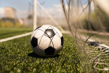 Yeşil çimlerde ve stadyum arka planında beyaz ve siyah futbol topu. Spor bahisleri