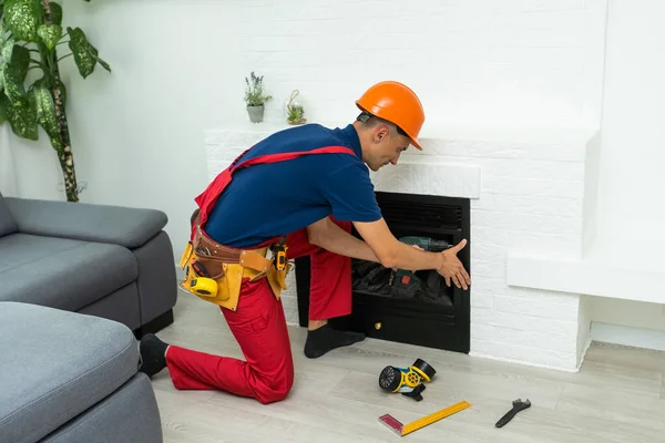 Service technician working on a fireplace inside of a residential home.