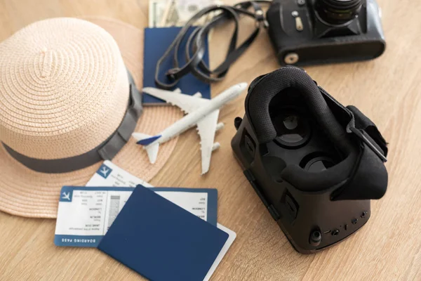 Flat lay composition of vr headset, travel accessories on a wooden floor. Virtual Tourism. Top view