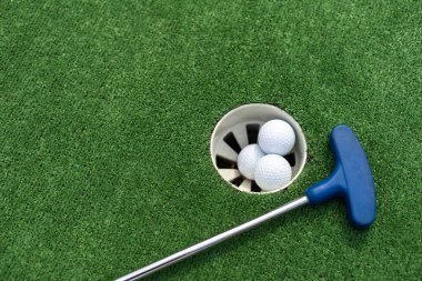 Minyatür golf delik ile sopa ve top yakın çekim.