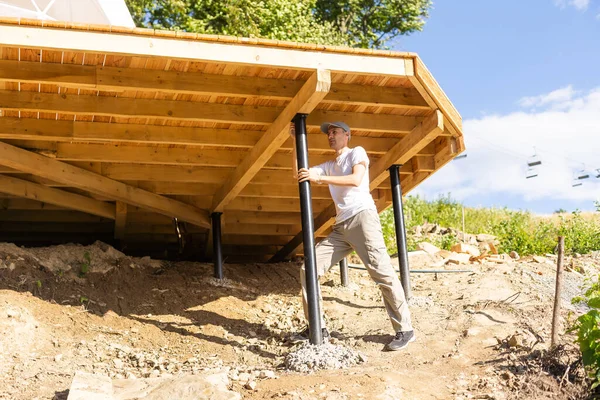 the craftsman builds a wooden terrace.