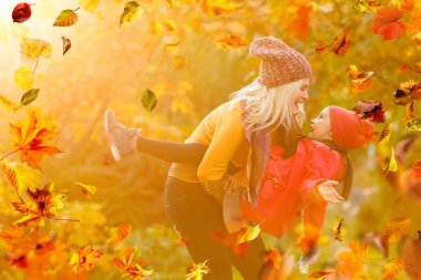 happy family: mother and child little daughter play cuddling on autumn walk in nature outdoors. High quality photo