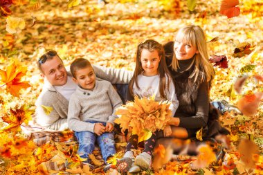 family walking in an autumn park with fallen fall leaves. High quality photo