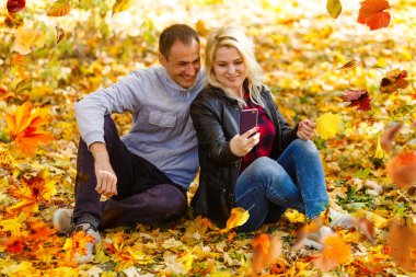 Young couple in love holding hands and walking through a park on a sunny autumn day. High quality photo
