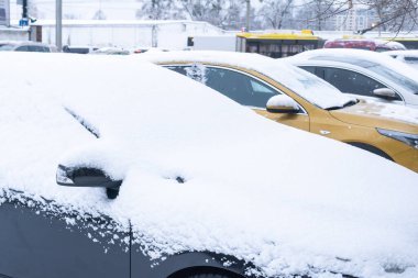 Car parked on street under winter snow fall.