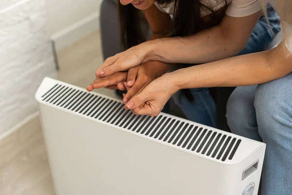 Mor Och Barn Uppvärmningen Händer Nära Elektrisk Värmare Hemma Närbild — Stockfoto