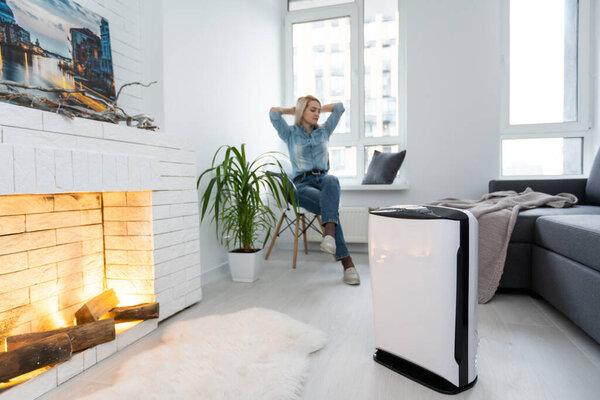 woman and air purifier at home. air humidification