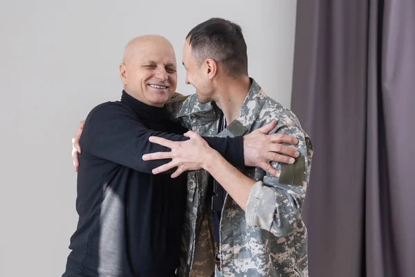 Military father hugs his son when they are reunited after a mission.