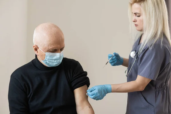 Junge Ärztin Spritzt Älteren Mann Bei Hausbesuch Impfstoff — Stockfoto
