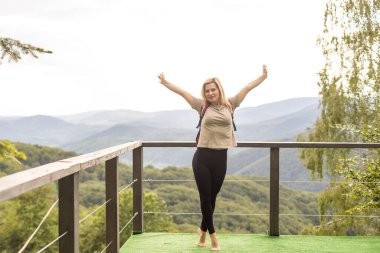 Yürüyüşten sonra dinlenen kadın yürüyüşçü. Turistler dağ tepelerinin ve sabah gökyüzünün tadını çıkarıyorlar. Seyahat, yürüyüş kavramı