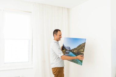 a man is holding a photo canvas.