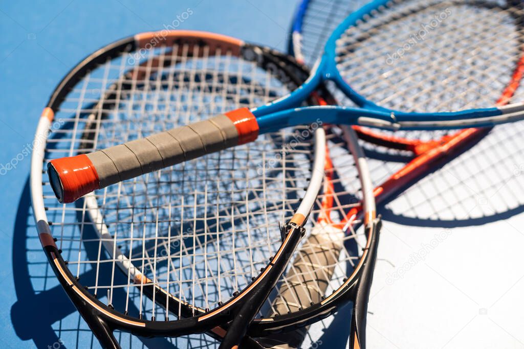 broken tennis rackets blue tennis court.