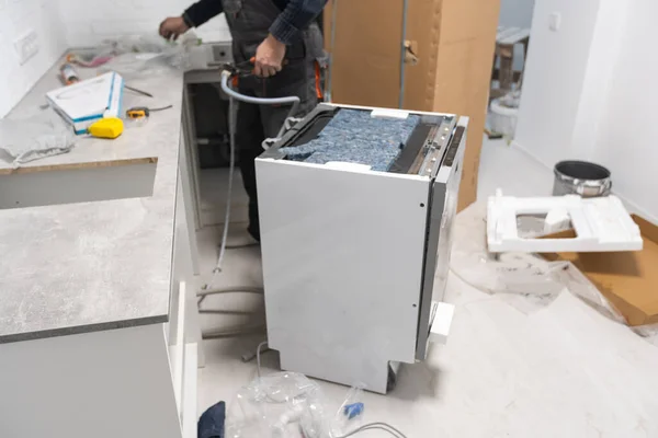 싱크대 밑에서 일하는 기술자가 식기세척기를 설치하는 — 스톡 사진