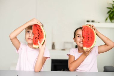 Komik küçük kız evde taze sulu karpuz yeme.