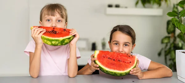 2人の女の子は自宅で孤立スイカを食べる — ストック写真