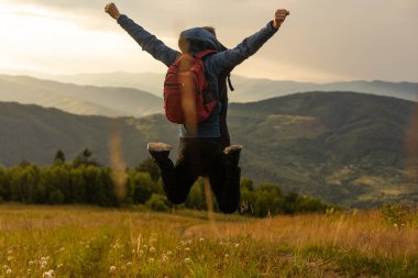 Sırt çantasıyla dağlarda gezen bir adam Seyahat yaşam tarzı başarı konsepti açık havada gezintiler spor hippi kıyafetleri.