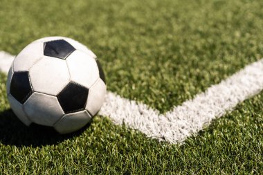 Yeşil çimlerde ve stadyum arka planında beyaz ve siyah futbol topu. Spor bahisleri