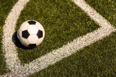 Yeşil çimlerde ve stadyum arka planında beyaz ve siyah futbol topu. Spor bahisleri