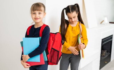 Konuşan ve sırlarını paylaşan iki küçük kız öğrenci. Eğitim, moda, arkadaşlık kavramı