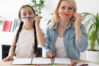 liseli kız ve anne evde ödev yapıyorlar..
