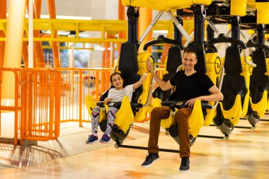 Baba ve kızı lunapark treninde eğleniyorlar..