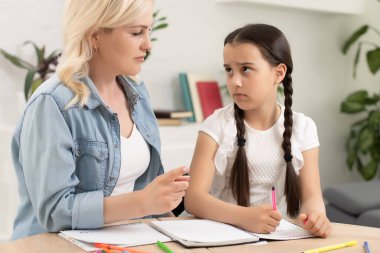 Anne ve kız birlikte ev ödevi yapıyorlar..