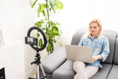 blogcu kadın yuvarlak lambayla video kaydediyor.