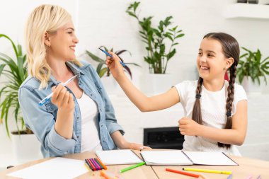 Anne ve kızı evde resim çizerek vakit geçiriyorlar..