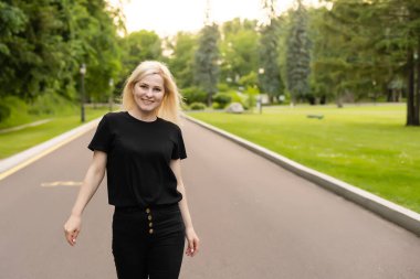 Çekici genç bir kadın yol boyunca yürür ve doğanın tadını çıkarır.