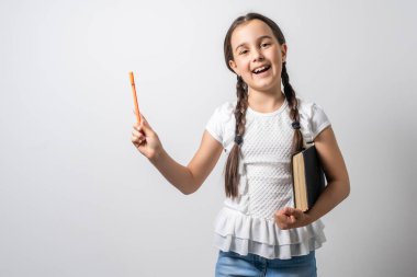 Esmer küçük kız, beyaz arka planda izole edilmiş bir kitap okuyor..