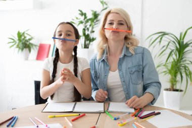 Anne ve kız birlikte ev ödevi yapıyorlar..