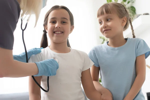 Dokter Met Een Stethoscoop Controleert Twee Kleine Meisjes — Stockfoto