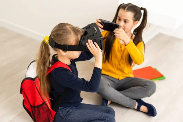 Kulaklık takmış iki kız sanal gerçeklikte. Çocukluk çocukları eğitim yaşam tarzı konsepti.