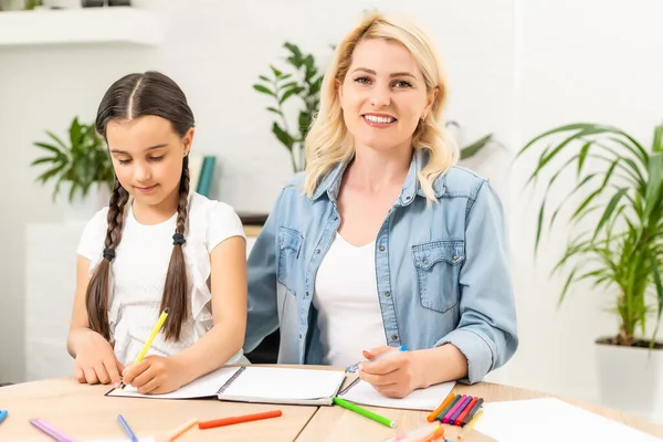 liseli kız ve anne evde ödev yapıyorlar..