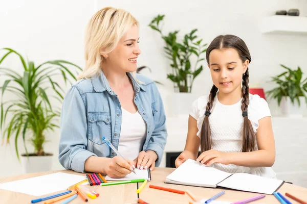 Anne ve kızı evde resim çizerek vakit geçiriyorlar..