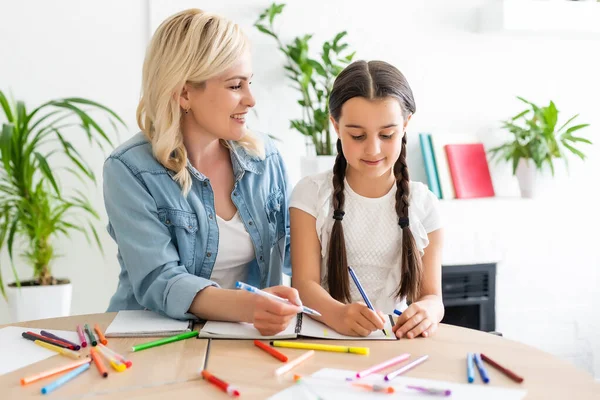 liseli kız ve anne evde ödev yapıyorlar..