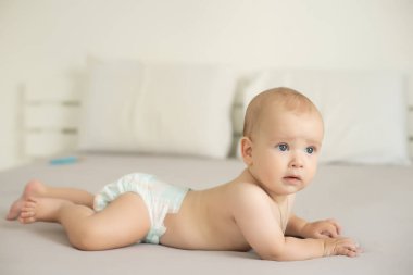 Odasındaki yatakta emekleyen bir bebeğin portresi..