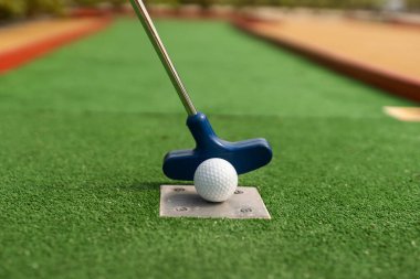 Mini golf oyun sırasında bir topa vurmak bir kulüp hazırlar.