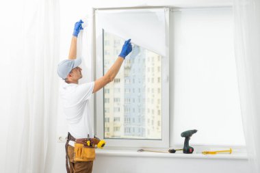 Usta plastik bir pencereye çift camlı yeni bir pencere takar.